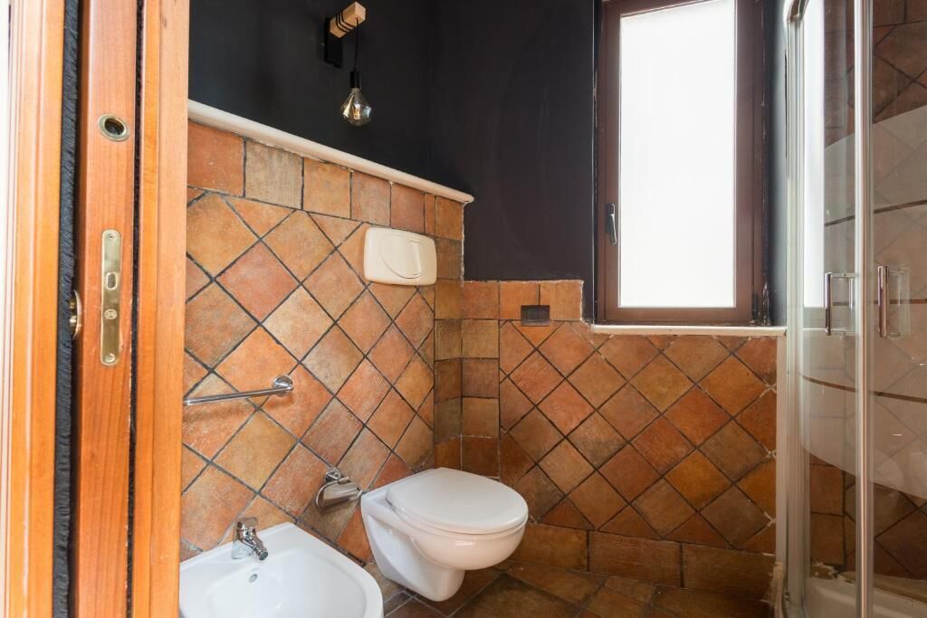 A bathroom with a white toilet, a sink, and a shower area.