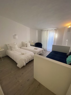 Ein Hotelzimmer mit zwei Betten, einem kleinen Tisch und einem Stuhl.