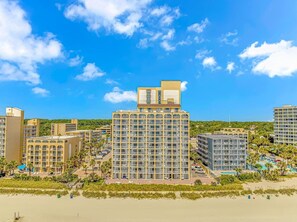 Ein Hochhotel mit mehreren Etagen, einer Dachterrasse und einer Lage direkt am Strand.