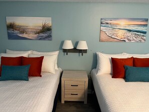 Ein Hotelzimmer mit zwei Betten, einem Nachttisch und zwei Wandlampen.