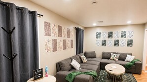 A modern living room with a sectional sofa, a round coffee table, and a small side table.