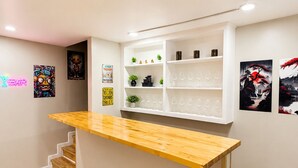 A reception area with a wooden counter, white shelving, and artwork on the walls.