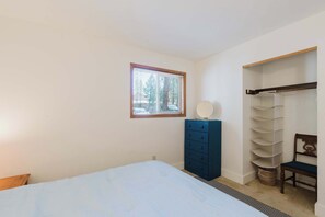 Ein Schlafzimmer mit einem Bett, einem Schminktisch, einem Spiegel und einem Kleiderschrank.