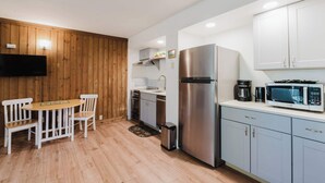 A compact kitchen with a dining area, a stainless steel refrigerator, a microwave, and a coffee maker. - 1BR Condo w/Game Room, Pool & Hot Tub (Bend)