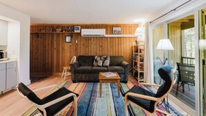 A cozy living room with a sofa, chairs, a coffee table, and a bookshelf. - 1BR Condo w/Game Room, Pool & Hot Tub (Bend)