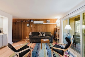 Ein gemütliches Wohnzimmer mit einer Couch, Sesseln, einem Couchtisch und einem Bücherregal.