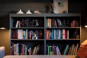 Ein Bücherregal mit Büchern, einem gerahmten Bild und dekorativen Gegenständen.