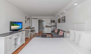 A modern apartment with a large bed, a TV, a kitchenette, and a dining area. - The Tidal Residence | SM Twenty Oh One Oh Two (Myrtle Beach)