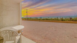 A paved outdoor area with a view of the beach and ocean, a white table, and a white chair. - Sea Mist 20102 Ocean Front Condo (Myrtle Beach)