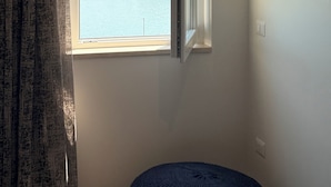 Een kamer met uitzicht op een waterpartij en een stadsgezicht.
