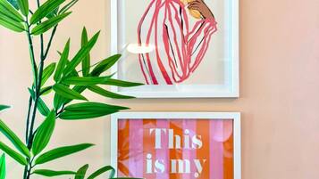 Two framed artworks on a wall, one depicting a person holding a flower and the other with the text 'This is my happy place.'