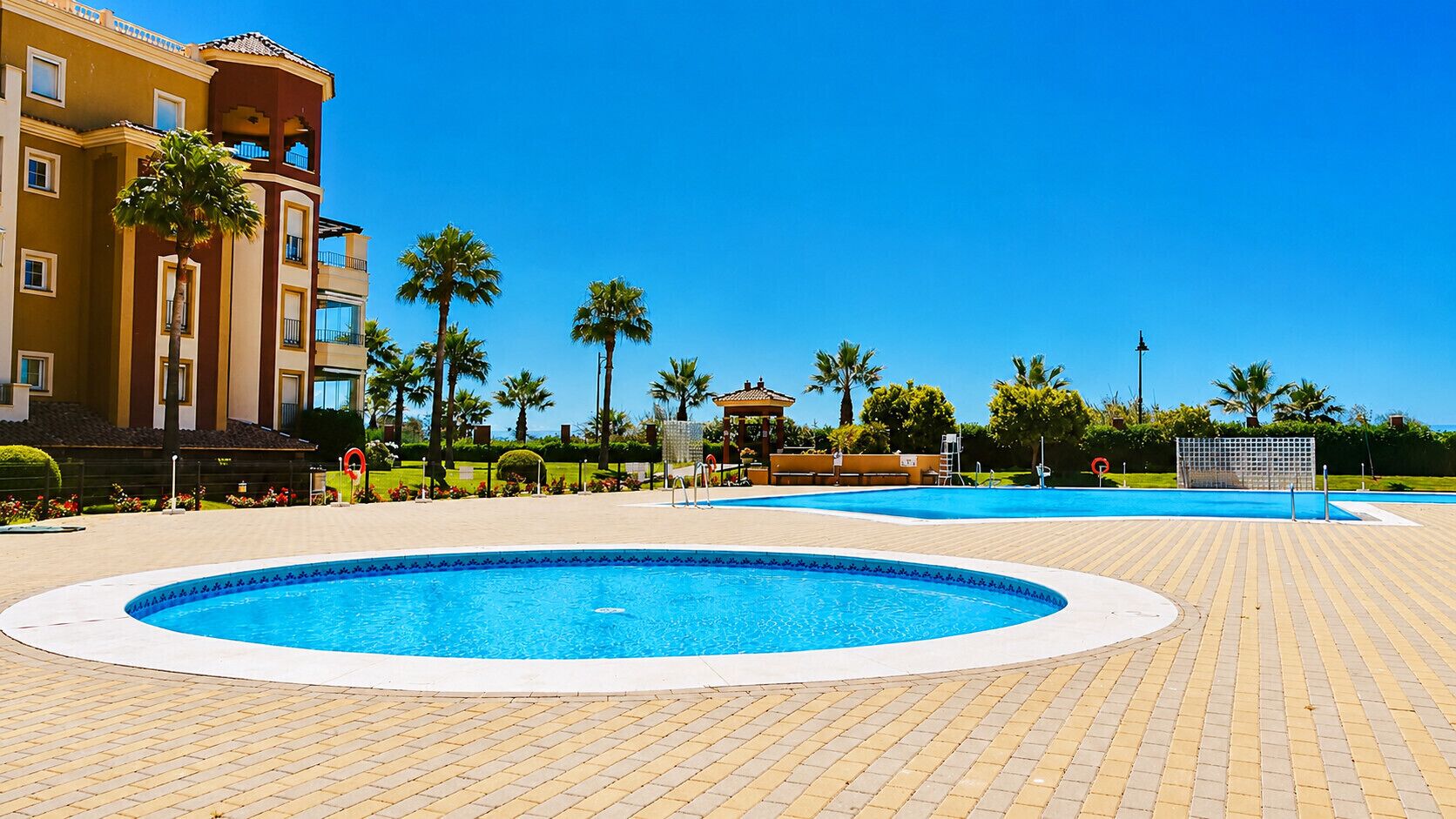 A swimming pool area with a building in the background.