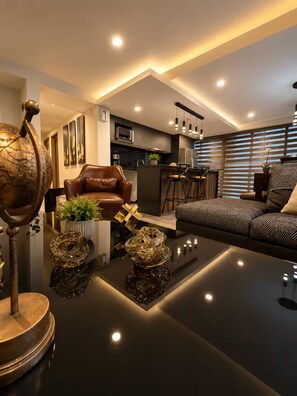 Ein modernes Wohnzimmer mit einer Couch, einem Couchtisch und einem Essbereich mit Barhocker.