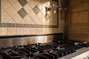 A kitchen with a gas stove and a decorative backsplash.