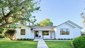 A two-story house with a front porch, a covered entryway, and a well-maintained lawn. - The Ayres House North Gilham-UofO-Autzen-Oakway, Putting Green Large Turfed Yard (Eugene)