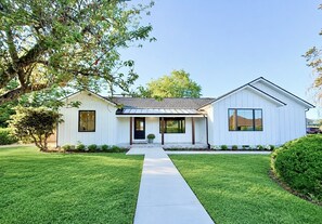 A two-story house with a front porch, a covered entryway, and a well-maintained lawn. - The Ayres House North Gilham-UofO-Autzen-Oakway, Putting Green Large Turfed Yard (Eugene)