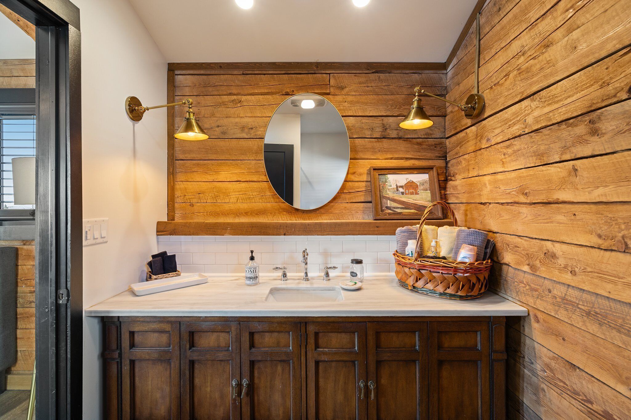 Rustic-chic bathroom with warm wood accents and elegant brass lighting