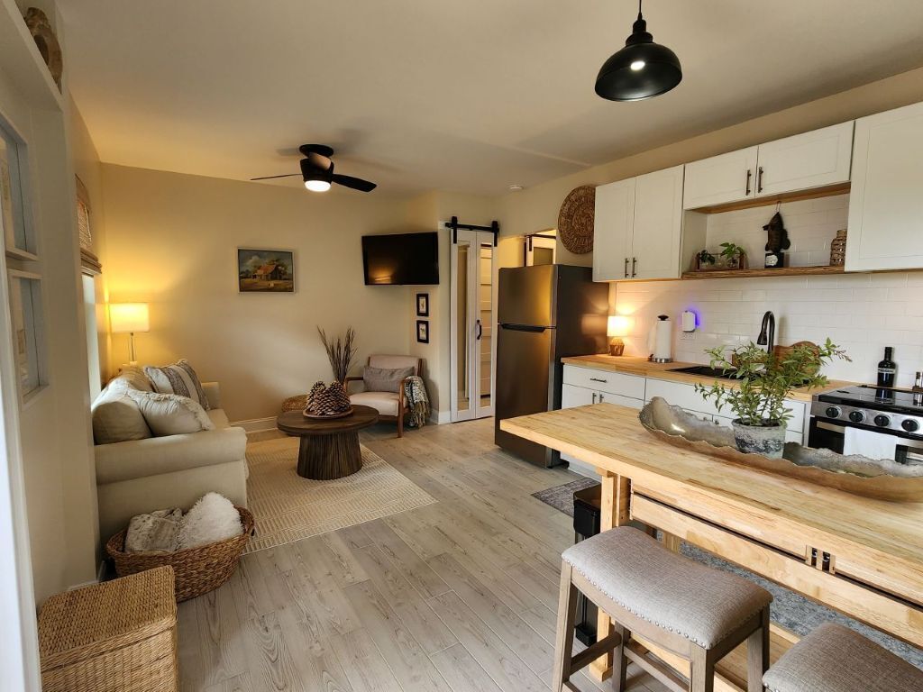 Una cocina moderna con encimera de madera, horno empotrado y refrigerador.
