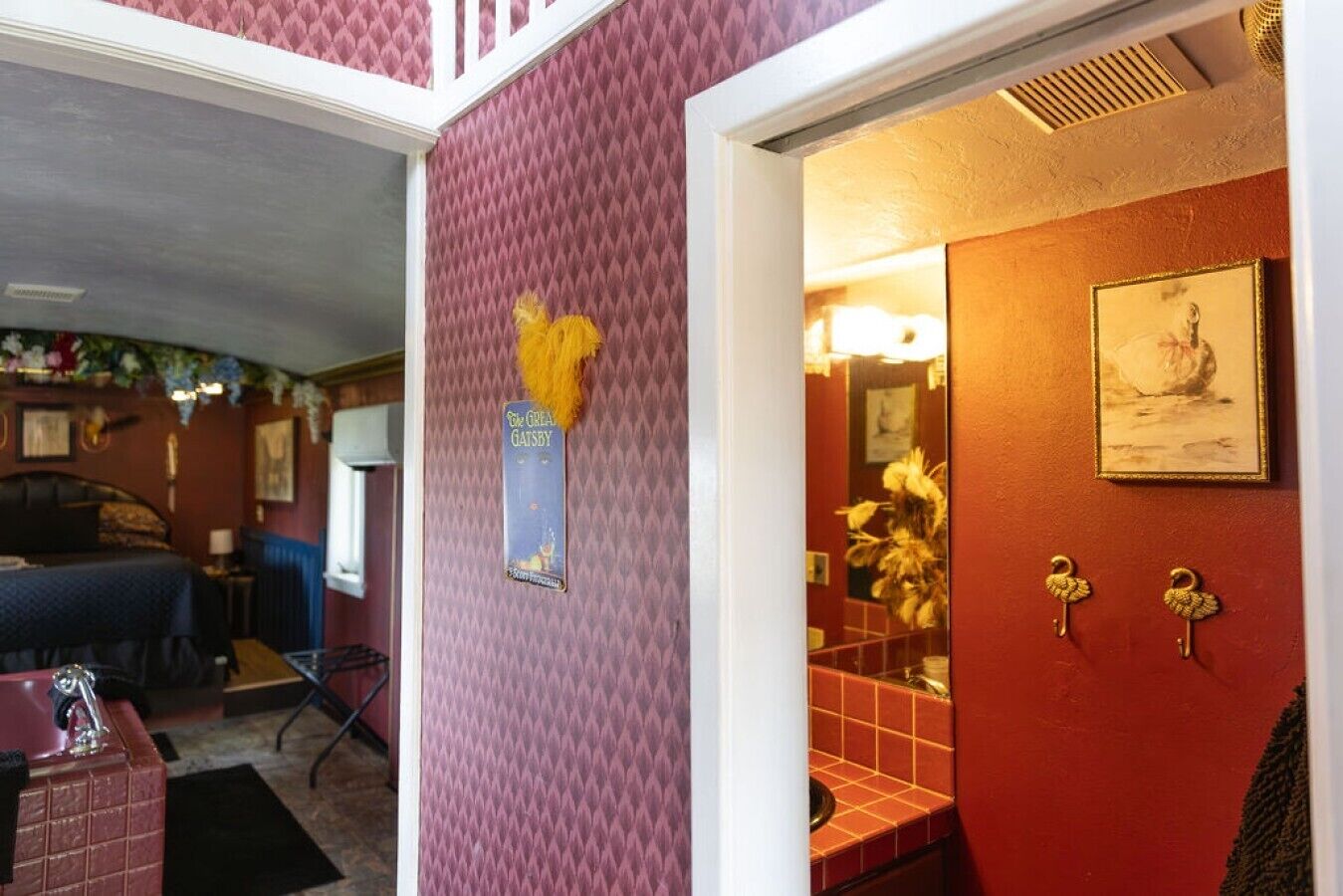 Ein Hotelzimmer mit Bett, einem Badezimmer mit Spiegel und einer Tür mit Schlüsselloch.
