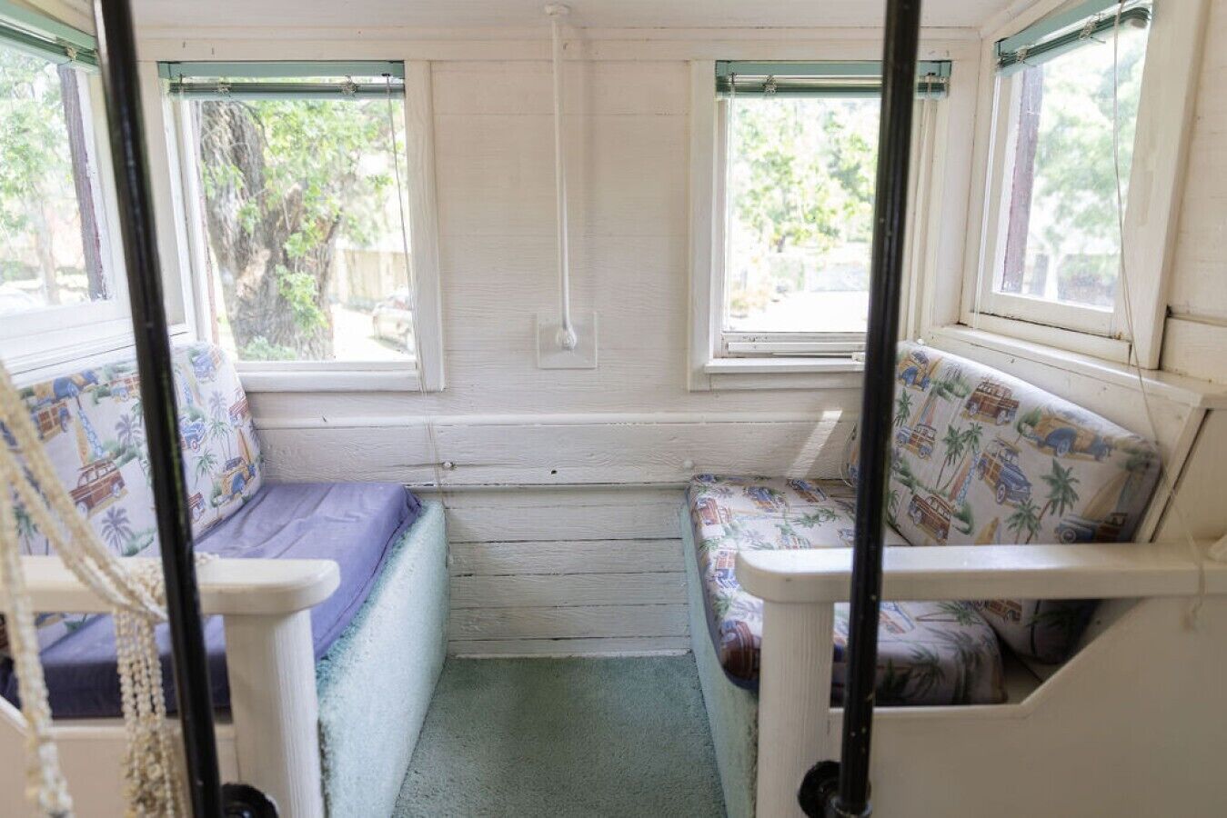 Un espacio reducido y cerrado con dos ventanas, un banco y una pequeña mesa.