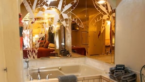 Een badkamer met een bad, een wastafel en een spiegel.