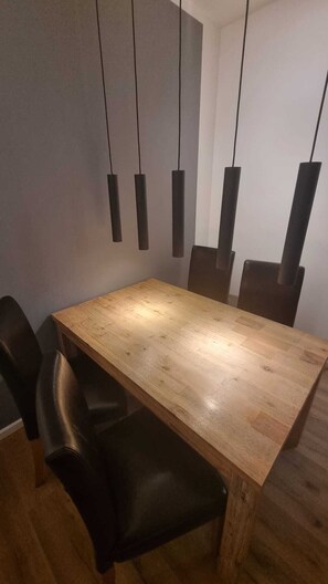 Ein Essbereich mit einem Holztisch und schwarzen Stühlen.