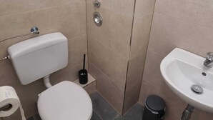 Et lille badeværelse med toilet, bidet og håndvask.