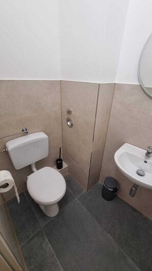 Ein kleines Badezimmer mit Toilette, Bidet und Waschbecken.