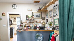 Een restaurant met een toonbank, een klok en ingelijste foto's aan de muur.