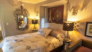 Een slaapkamer met een bed, twee bedlampen, een spiegel, een poster aan de muur en een hoofdbord.