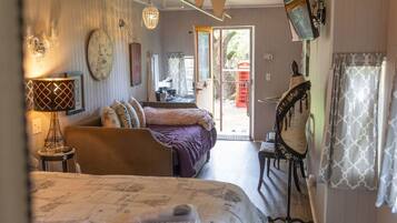 Een kamer met een bed, bureau, stoel, lamp, klok en raam.