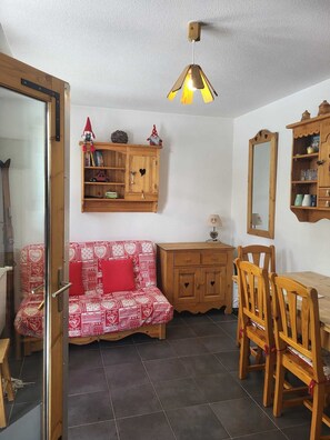 Ein gemütliches Zimmer mit einer Holzdirekt, einem Esstisch mit Stühlen, einem Schrank und einer Pendelleuchte.