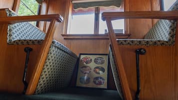 A wooden staircase with a patterned cushion and a framed picture of a cityscape.