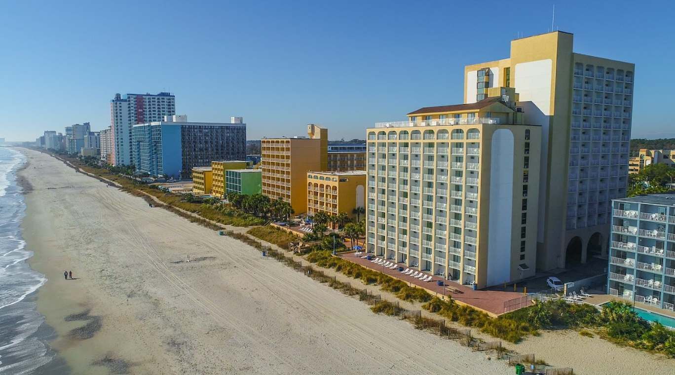 A coastal hotel with multiple floors, a beachside location, and a pool area.