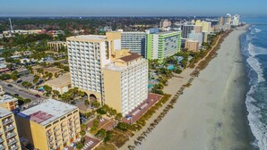 Un paisaje urbano costero con rascacielos, una playa y cielo despejado.