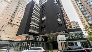 A modern building with a unique architectural design, featuring a prominent vertical element and large windows. - Conforto prox metrô e Estacionamento (São Paulo)