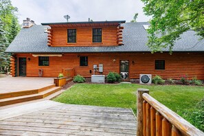 Eine Blockhütte mit einer Terrasse, einer Satellitenschüssel und einer Klimaanlage.