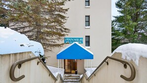 Eine Treppe führt zu einem Gebäude, an dem ein Schild mit der Aufschrift "Pinnacle Spa & Lounge" zu sehen ist.