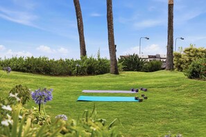 Una zona erbosa all'aperto con tappetini da ginnastica e manubri.