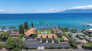 A resort with multiple buildings, a swimming pool, and a view of the ocean. - Mahina Surf 123 & 124 (Lahaina)