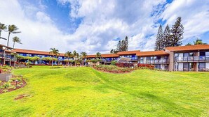 Ein Hotel mit mehrstöckigen Gebäuden, einem gepflegten Rasen und blauem Himmel.