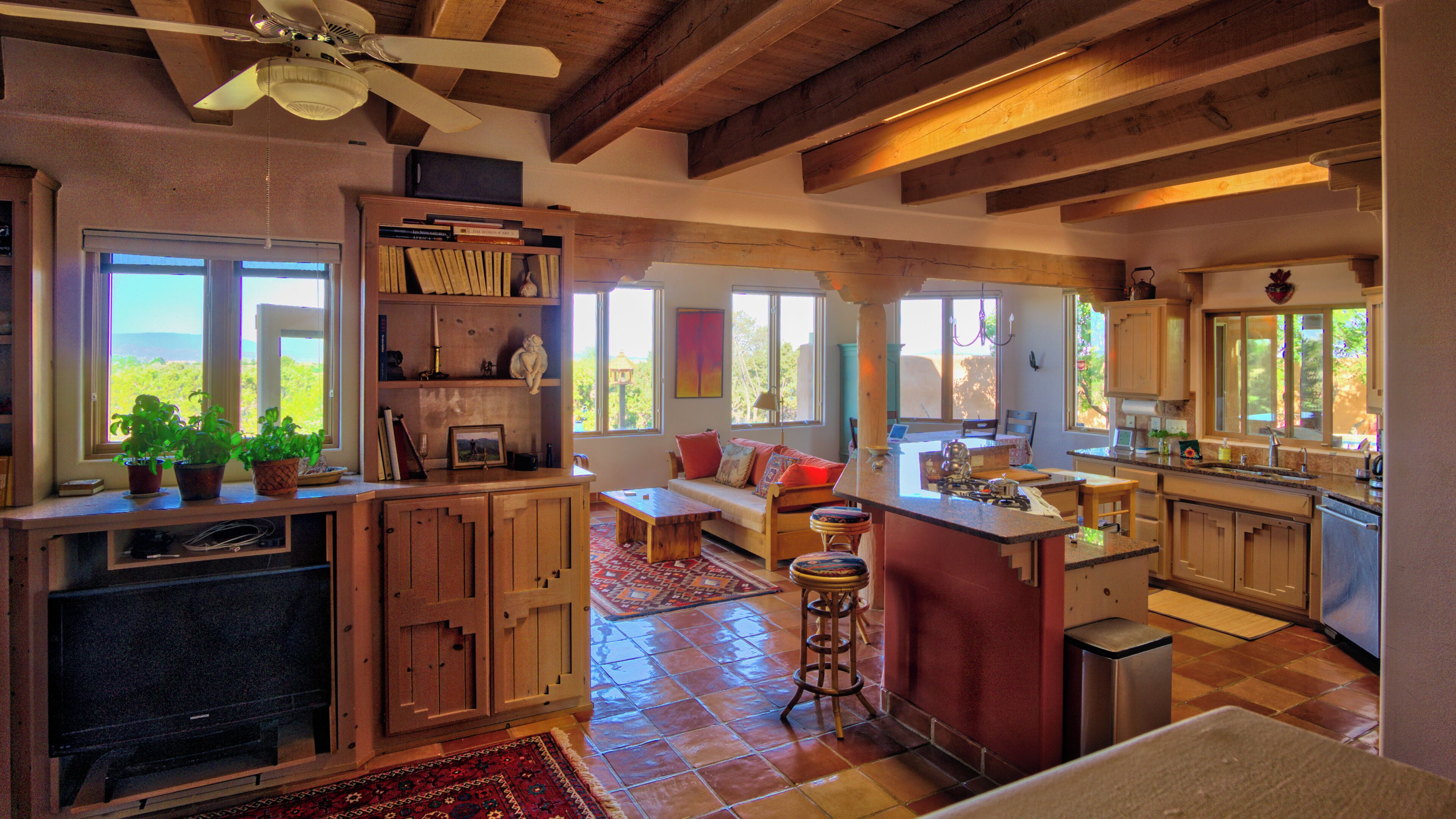 Un'ampia cucina con mobili in legno, un'isola grande e un'area pranzo con divano.