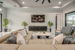 Una sala de estar moderna con un conjunto de sofá, una mesa de centro y un televisor montado en la pared.