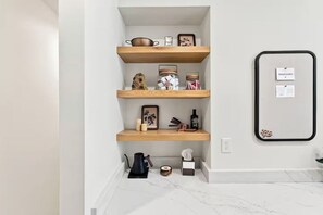 Ein schlichtes Interieur mit drei Holzböden, einem spiegelnden Schwarzrahmen und einem Marmorboden.