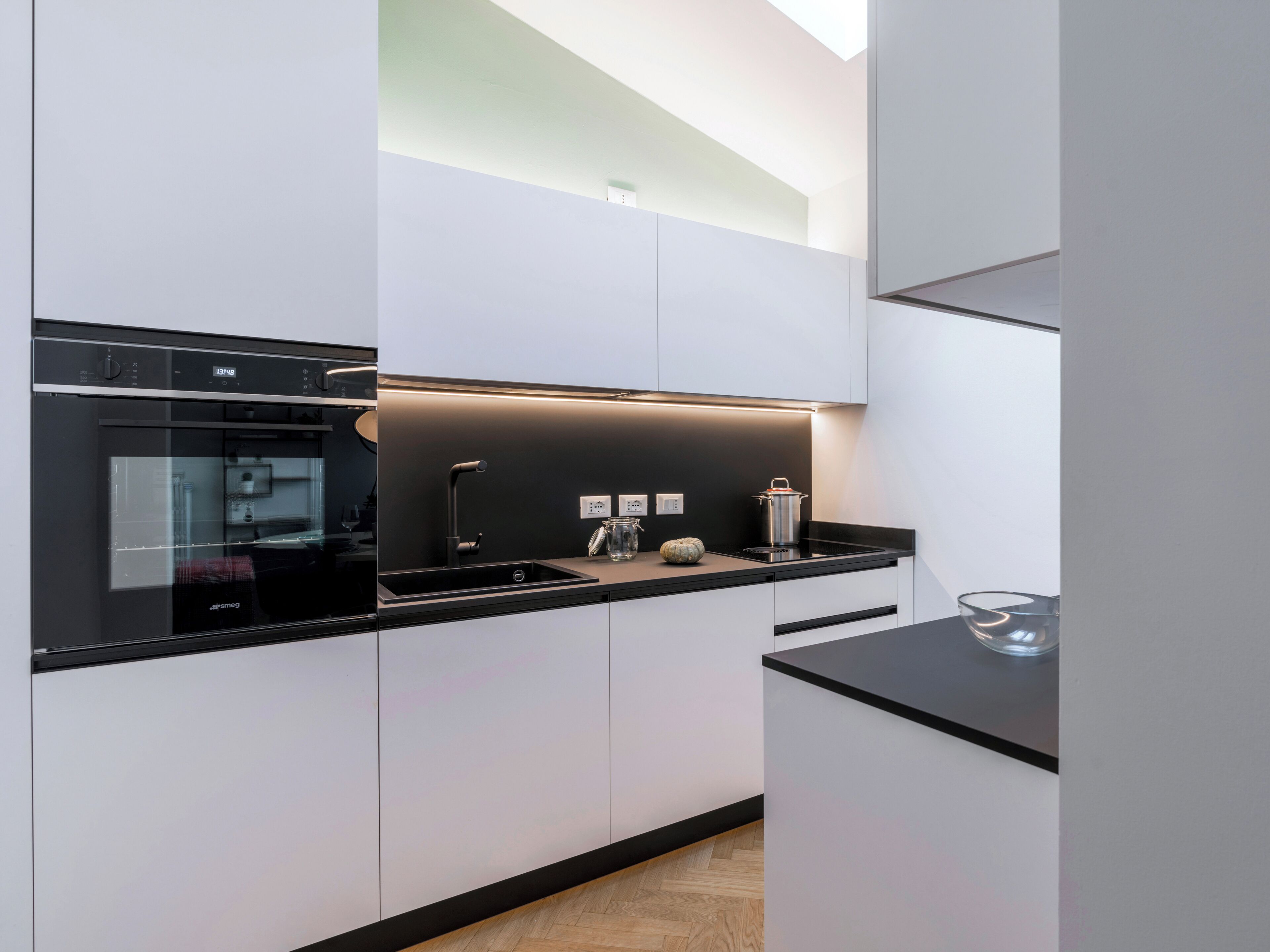 Una cocina moderna con horno empotrado, un lavabo y una encimera.