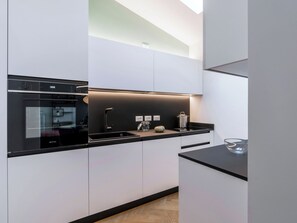Eine moderne Küche mit Einbauofen, Spüle und Arbeitsplatte.