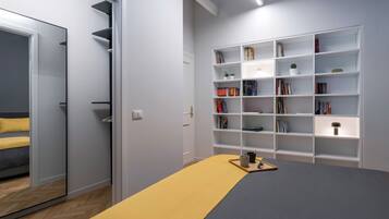 Ein Schlafzimmer mit einem Bett, einem Nachttisch, einem Bücherregal und einem Kleiderschrank.