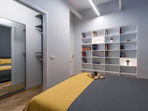 Ein Schlafzimmer mit einem Bett, einem Nachttisch, einem Bücherregal und einem Kleiderschrank.