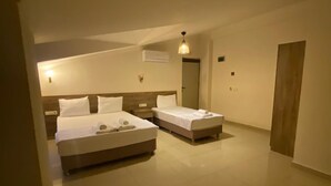 A hotel room with two beds, a large mirror, and a door.