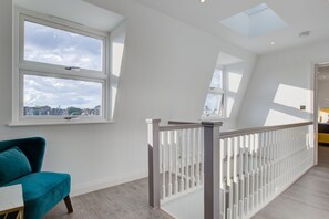 Una habitación amplia con techo alto, tragaluces y grandes ventanales que ofrecen vista a la ciudad.
